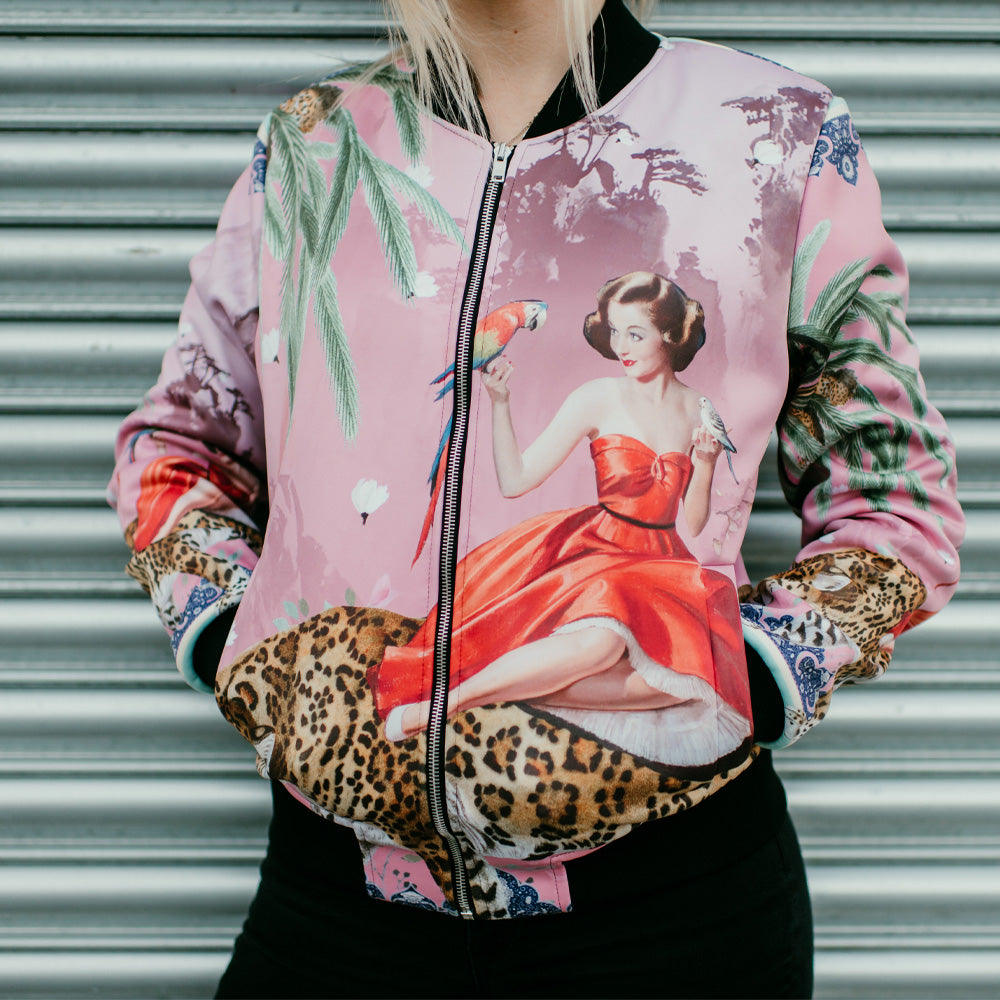 A female model wearing luxury softshell bomber jacket in a maximalist vintage pink design