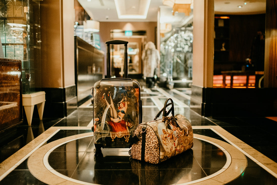Stunning Myrtle and Mary suitcase with duffle bag to the right hand side, placed in the foyer of a hotel.