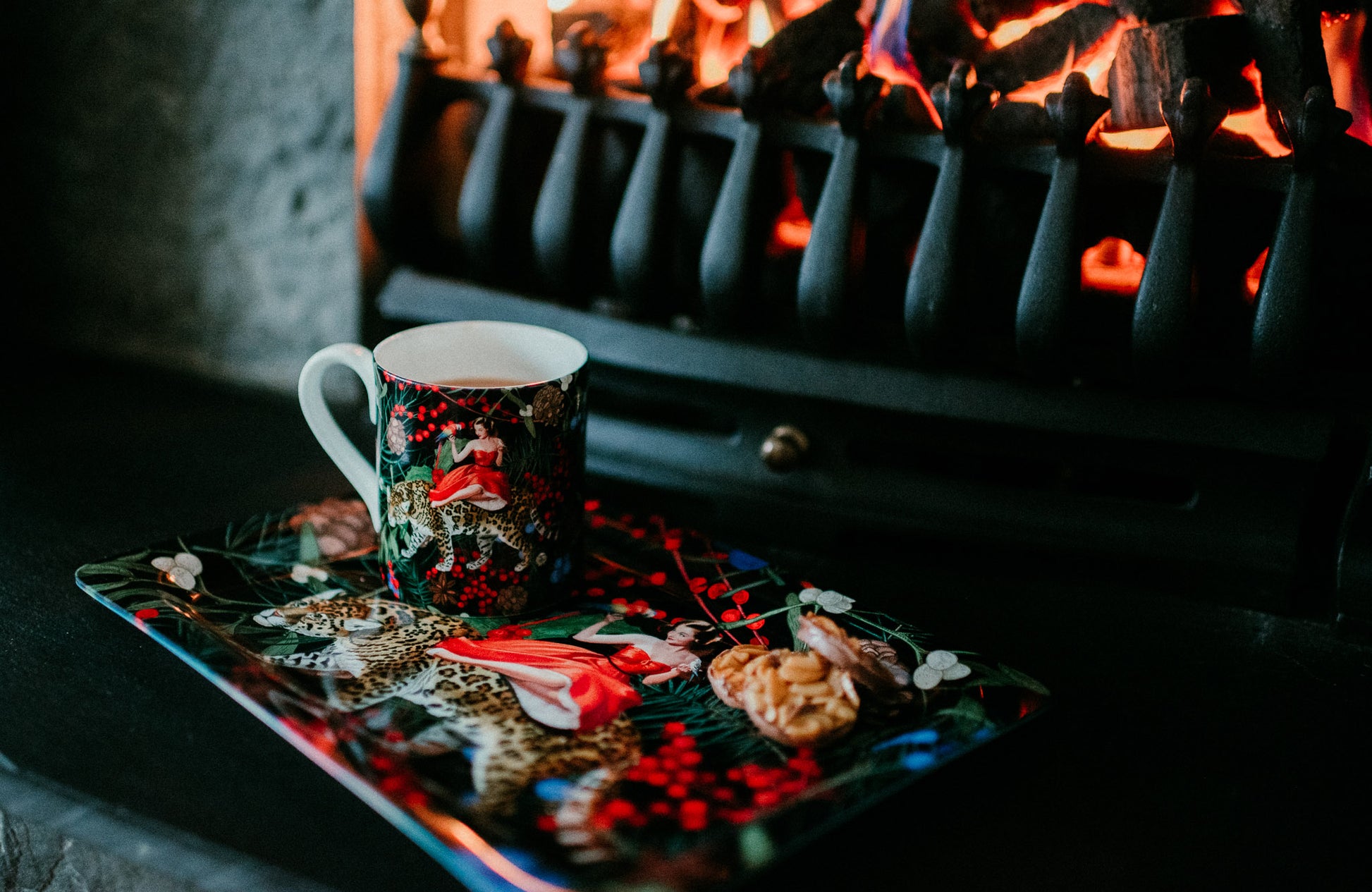 Luxury bone china coffee cup in a maximalist festive animal fairytale design called - Festive Mary on a tray in front of a fireplace
